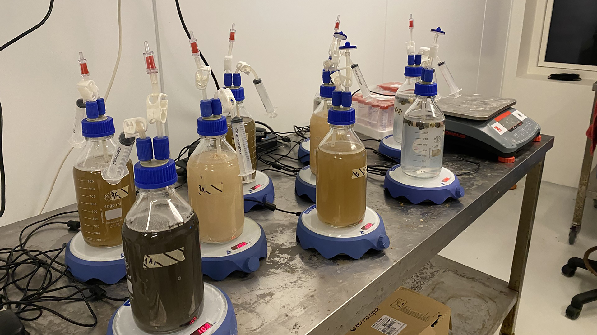 Forsøgsopstilling hvor væske i flasker bliver vejet